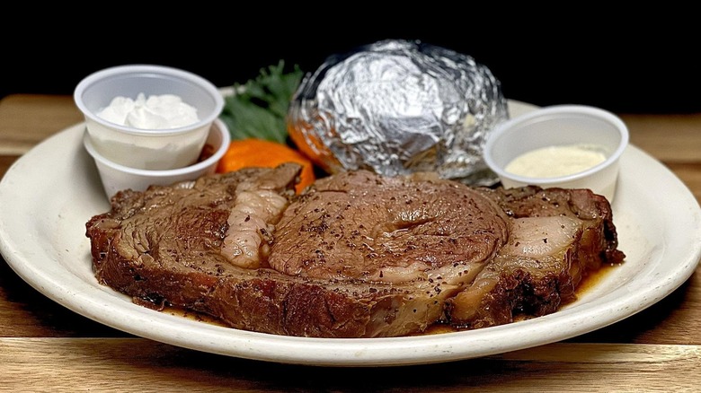 Prime rib steak served with foiled baked potato and condiments at The Turtle Club restaurant.