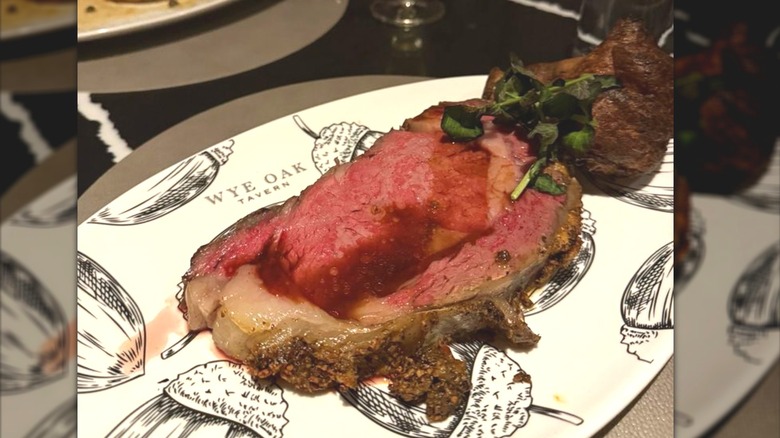 Prime rib, rosy meat and seasoned crust on plate with sketches of acorns at Wye Oak Tavern.