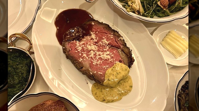 A slice of prime rib at La Tête d'Or topped with Bordelaise and Béarnaise sauces and a fresh grating of horseradish root.