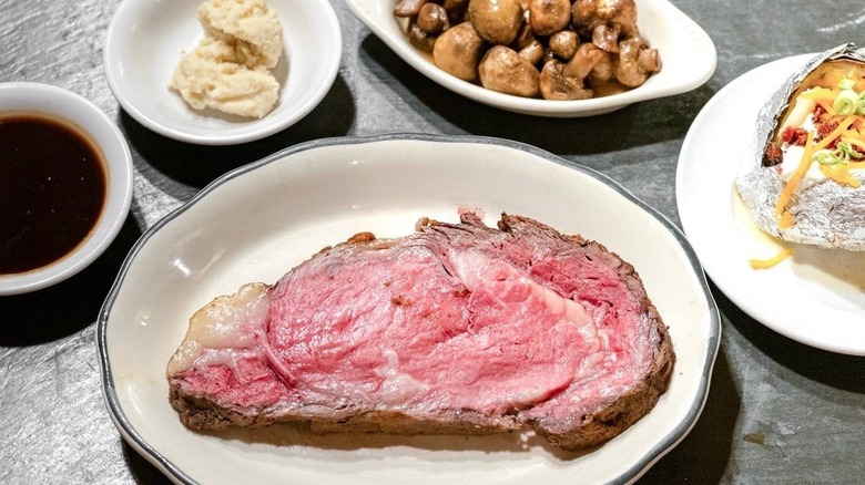 Lineberger's Steakhouse prime rib, served with au jus, horseradish, sauteed mushrooms, and loaded baked potato.
