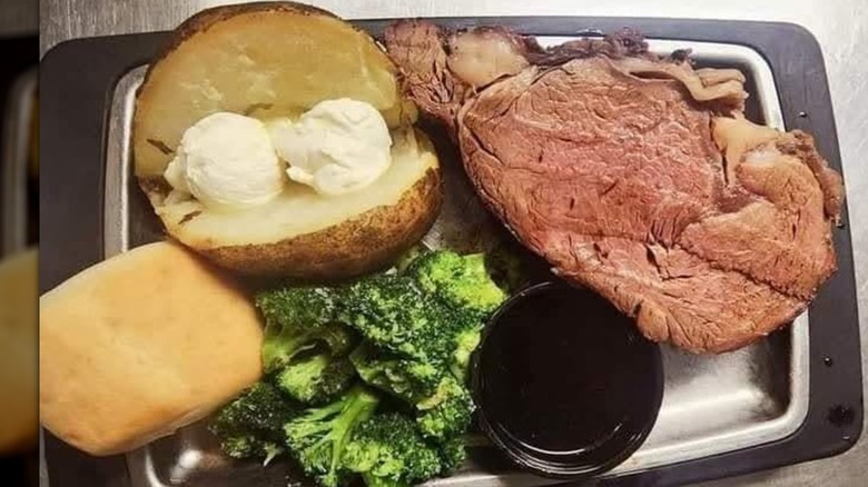 Smoked prime rib from Rusty's Saloon and Grill served with baked potato, broccoli, roll, and cup of au jus.