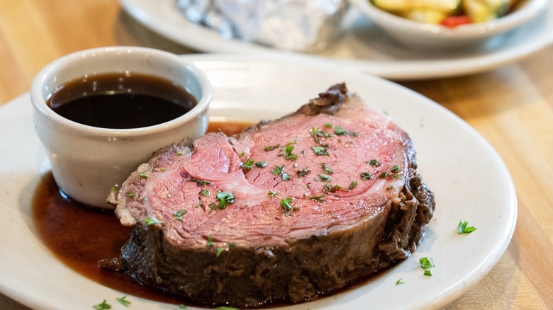 A 16 ounce prime rib cooked to perfection at Lindy's Tavern, served with home made au jus on plate.