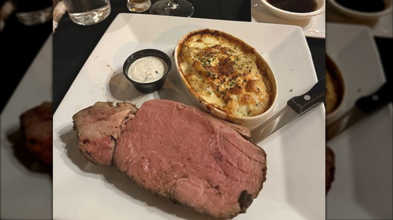 Medium rare prime rib with au gratin potatoes on plate at Hale House restaurant.