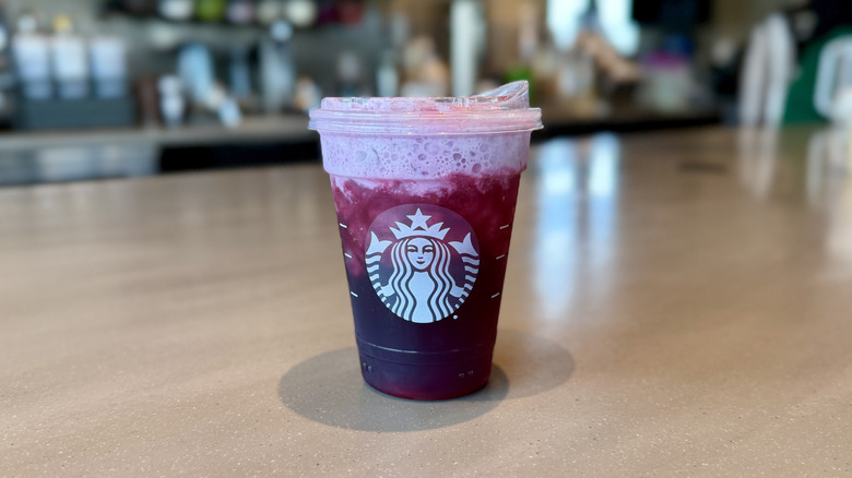 Starbucks' Hannah Montana Popstar Refresher pink drink in a cup on the counter