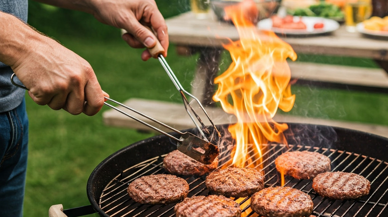 Cooking burgers over a charcoal grill