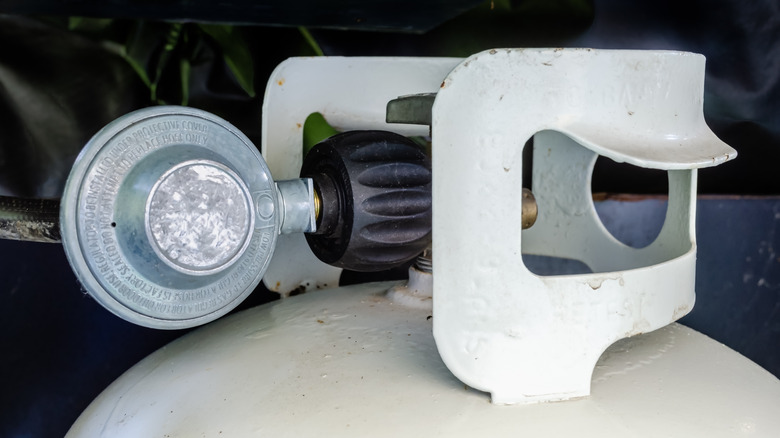 A propane gas tank with a regulator for grilling