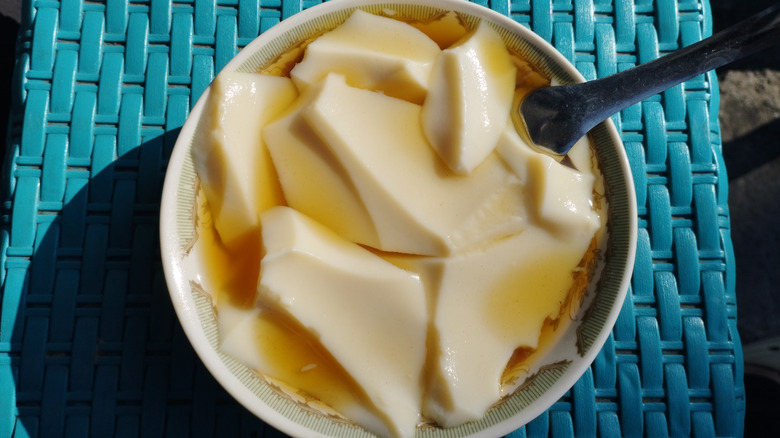Silken tofu in a sweet broth with a spoon