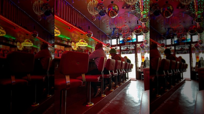 Orphan Andy's Restaurant interior, featuring patrons at the bar beneath colorful lights