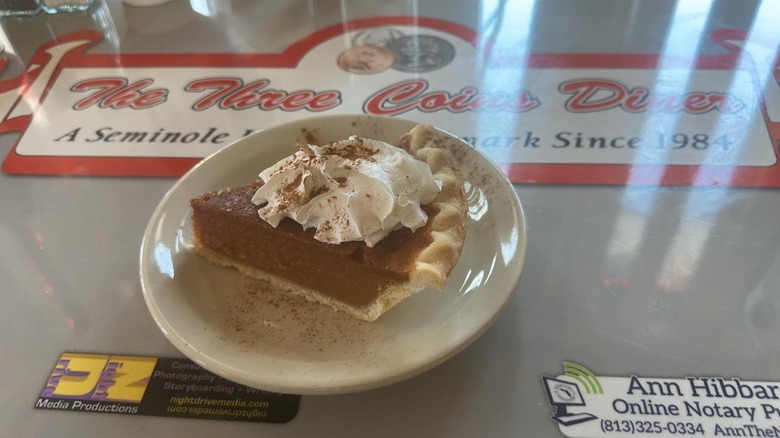 A plated slice of pumpkin pie on the counter at Three Coins Diner