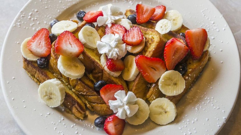 Nick's Patio Restaurant french toast topped with strawberries blueberries and banana and whipped cream
