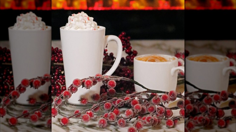 Mugs of custom coffee drinks styled with faux red berries in front of the fireplace at Lounge Nocherie
