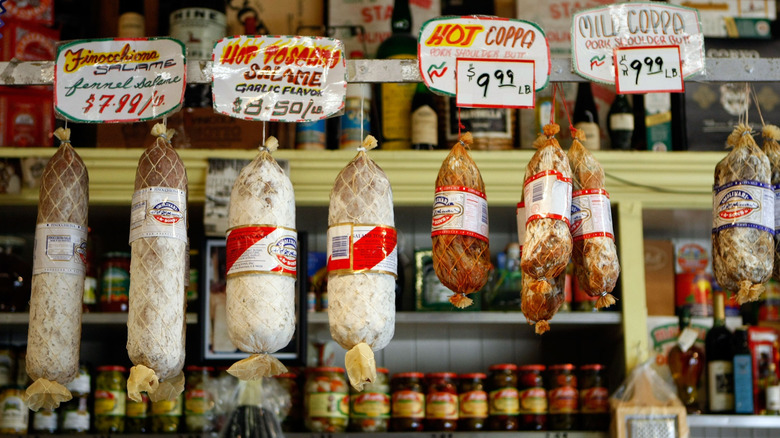Meats hanging from the ceiling of an Italian deli