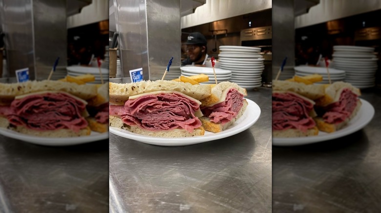 Pastrami sandwich on rye, in a restaurant kitchen.
