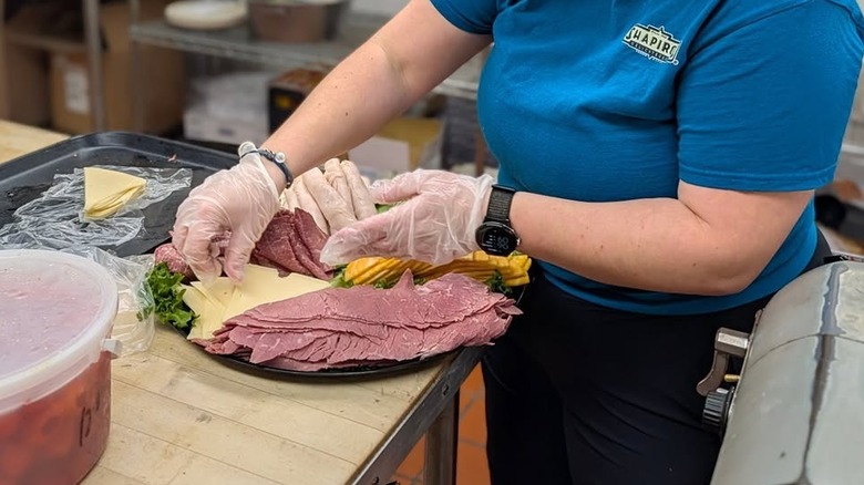 Worker at Shapiro's Deli putting together a platter