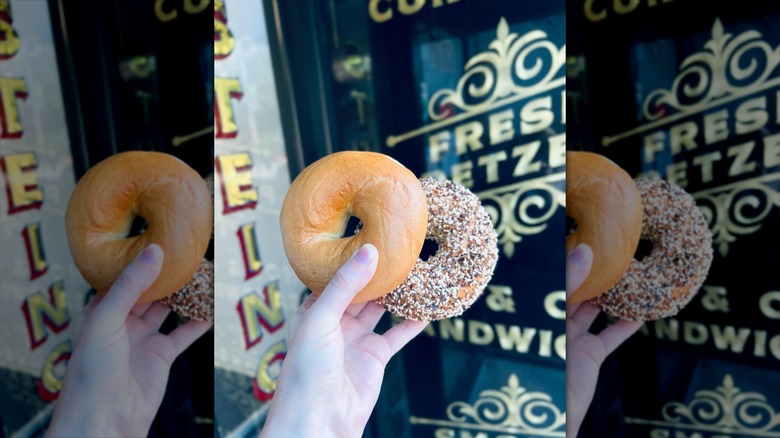 Two bagels being held in front of Steingold's Deli