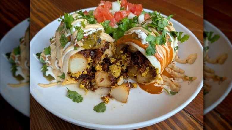 Vegan burrito with potatoes, vegan meat, and eggs covered in sauce from Vegos in N.E. Albuquerque, New Mexico