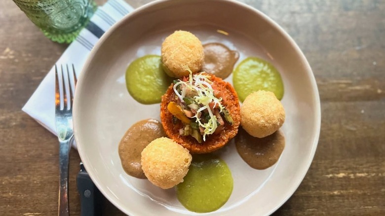 Vegan hominy corn fritters with refried quinoa, pipian verde & rojo, and squash escabeche from Vedge in Philadelphia, Pennsylvania