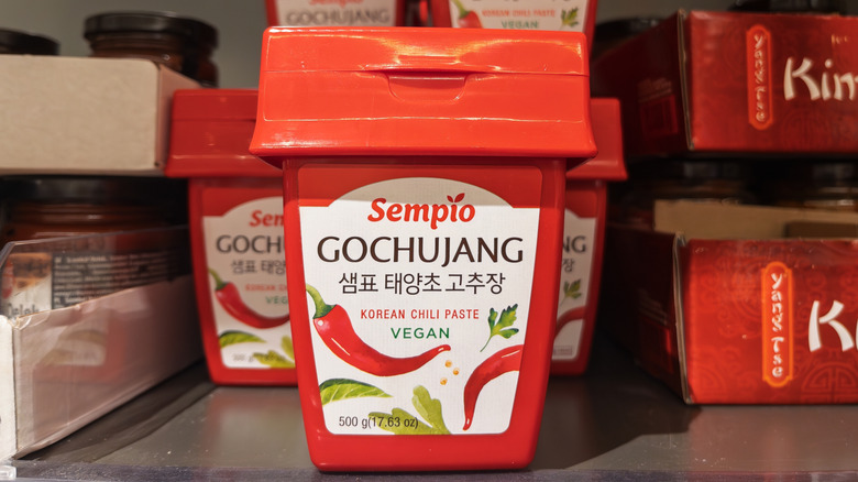 Several tubs of gochujang chili paste on a shelf
