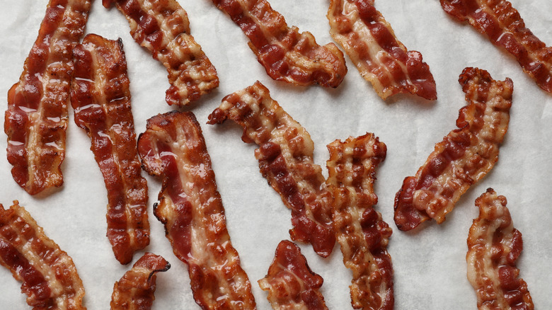 Strips of cooked bacon on parchment paper