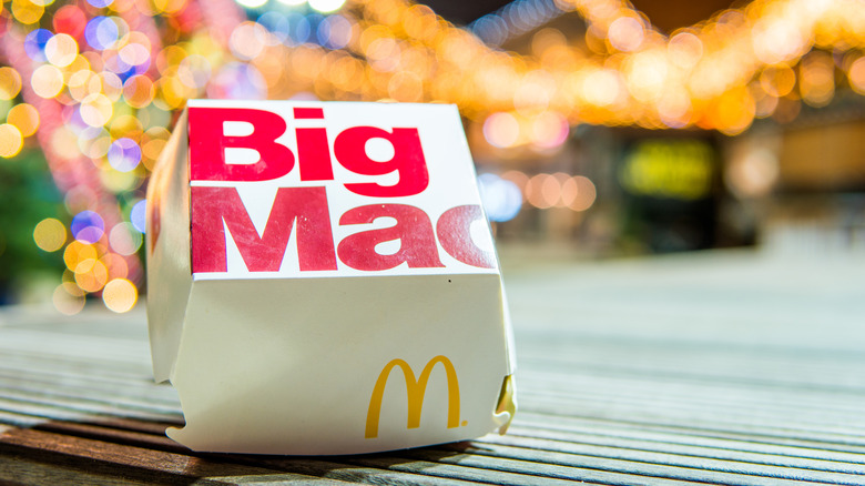 A Big Mac box from the 2010s outside with Christmas lights out of focus in the background