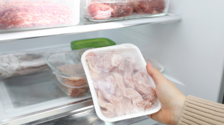 Woman taking frozen meat out of the freezer