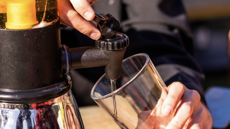 A man pours beer into a glass from an Oggi beer tower