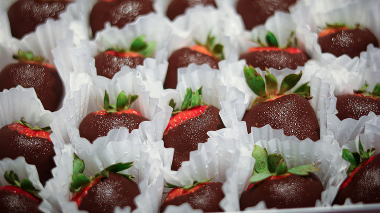 Chocolate-covered strawberries sit in wrapping with condensation