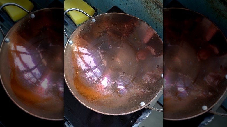 A wok being seasoned on the stove