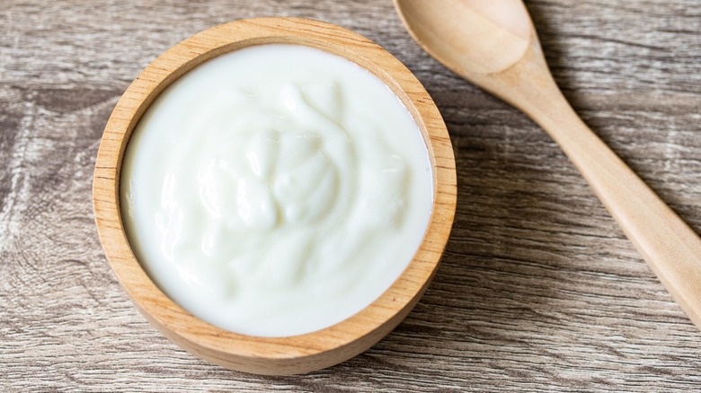 Plain yogurt in wooden bowl