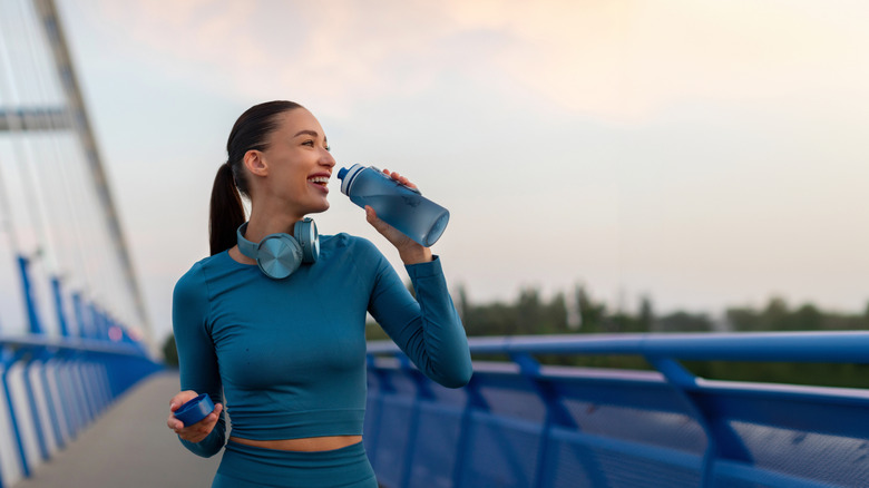 Woman drinking water while out on a run