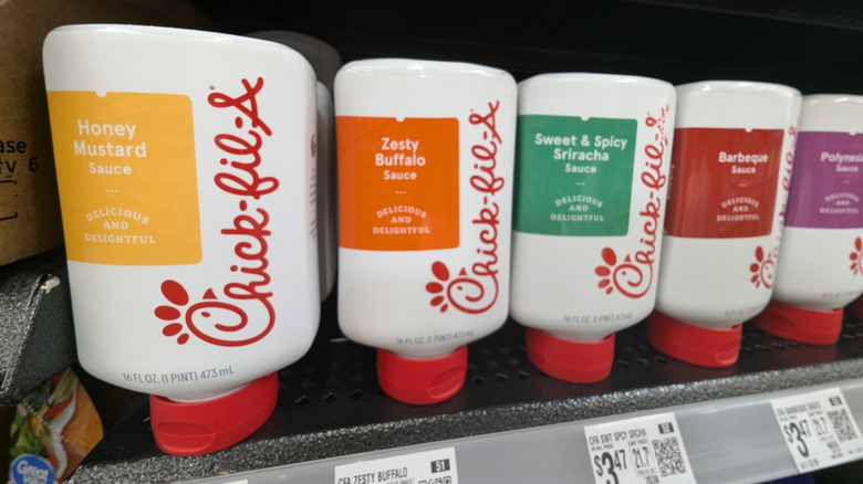 Bottles of Chick-fil-A sauces on a grocery store shelf.