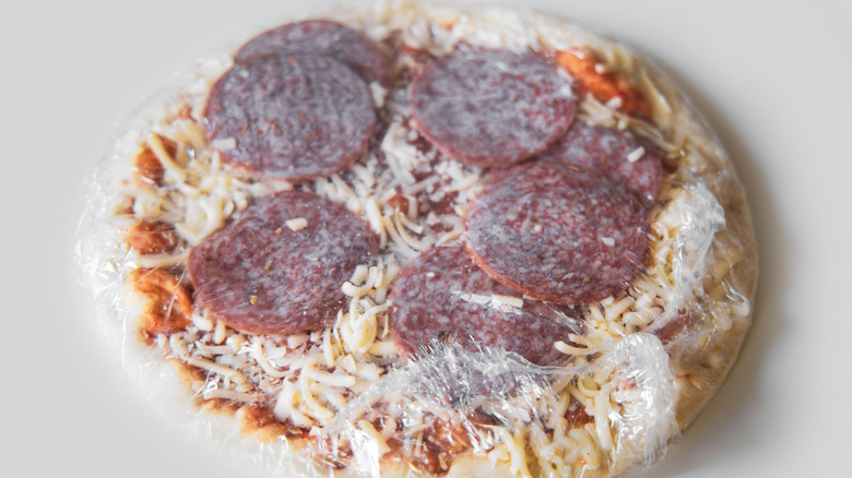 frozen pizza in plastic wrap