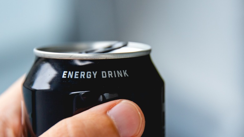 A close-up of a hand holding an energy drink