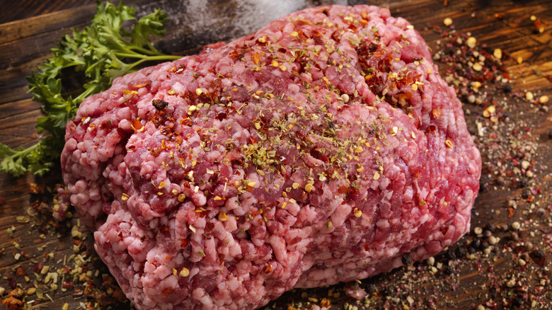 Hunk of ground lamb on a wood cutting board