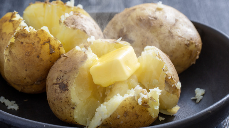 A pile of steaming potatoes with butter