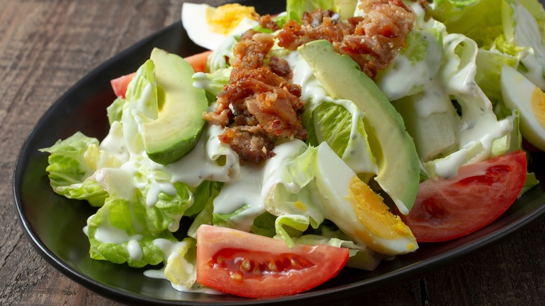 Salad with bacon, avocado, eggs, and tomatoes