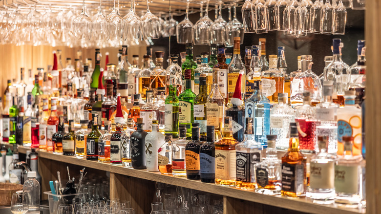 An array of bottles sitting behind a bar.