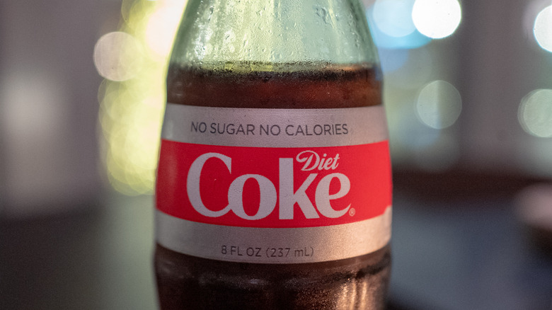 A close up of a diet coke in a glass bottle