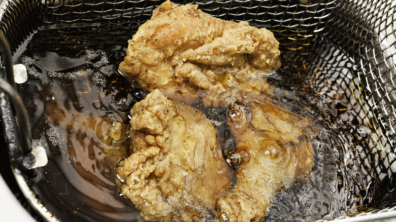 Chicken being deep fried in oil