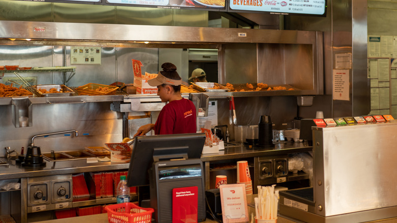 Popeyes worker preparing chicken