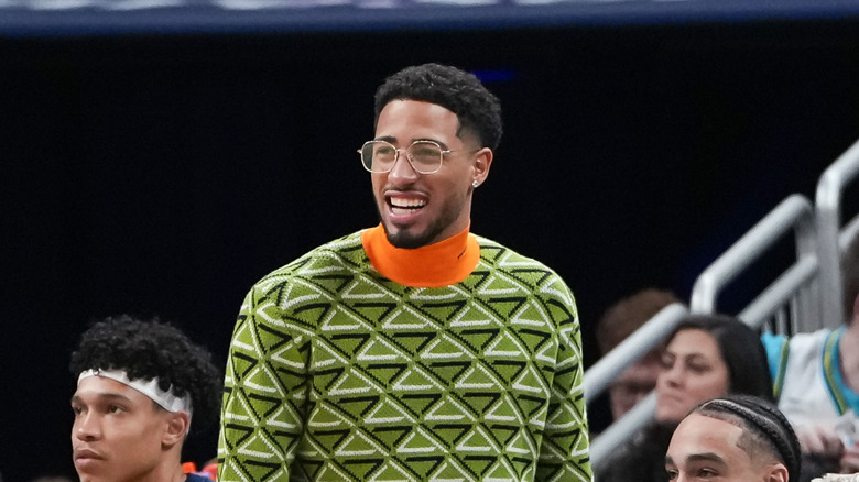 Tyrese Haliburton wearing a turtleneck on the sidelines of an NBA game