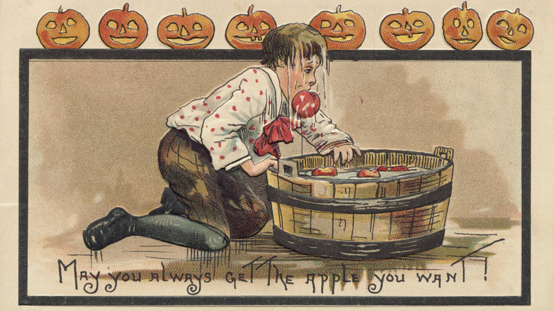 A vintage illustration of a boy bobbing for apples on Halloween