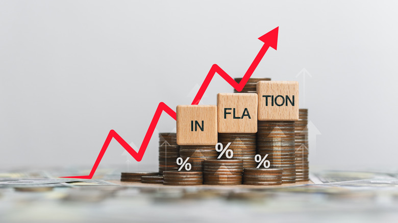 Stacks of coins of various heights with building blocks spelling out "inflation" on top of them