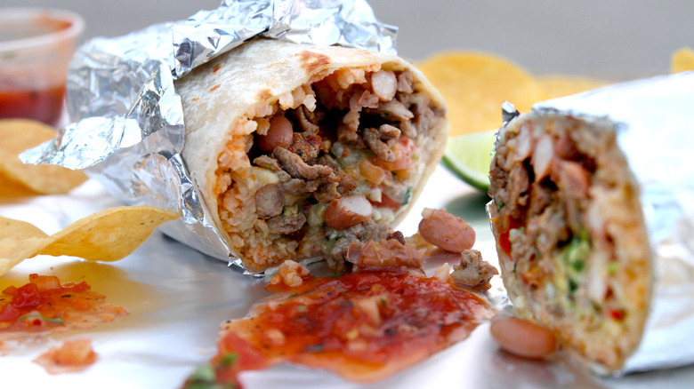 A cut-open Mission burrito with salsa and chips