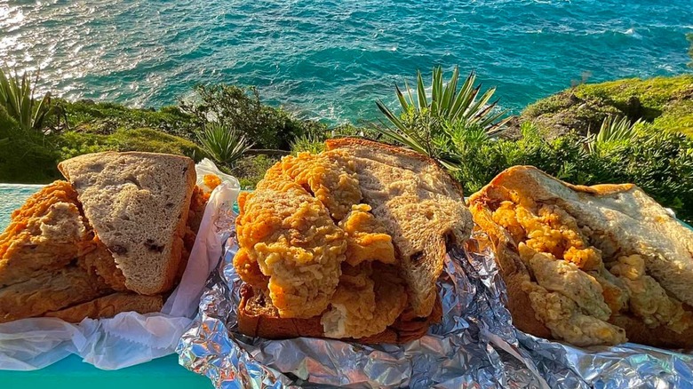 fish sandwiches from Art Mel's posed beachside