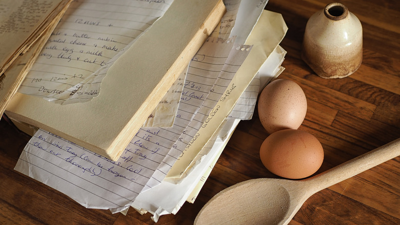 A pile of wrinkled and stained hand-written recipes on paper