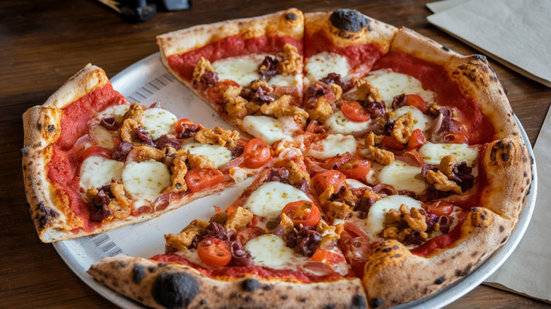 A pizza cut into slices and cooked well done