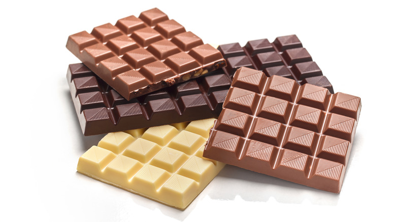 Various milk, dark, and chocolate bars on a white background.