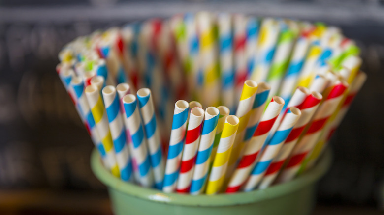 A variety of colored paper straws are shown in a cup