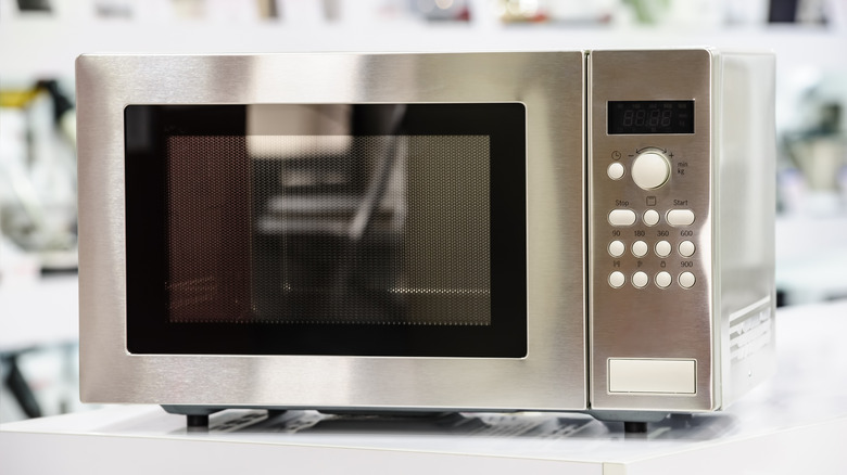 Stainless steel microwave oven sitting on a flat surface